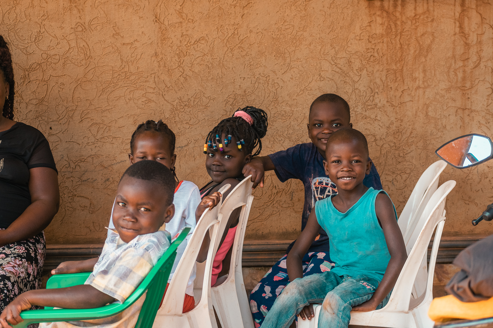 Bright, smiling children in our education outreach — orphans and vulnerable children supported by Held at Heart Uganda across Uganda.
